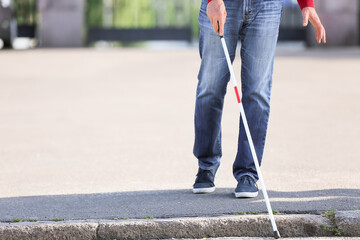 Blind senior man crossing road in city