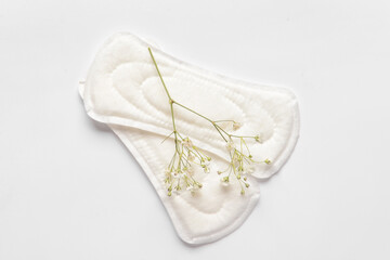 Menstrual pads and gypsophila flowers on white background