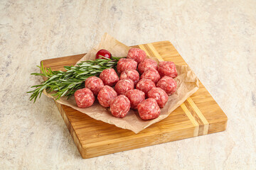 Raw uncooked beef meatballs served rosemary