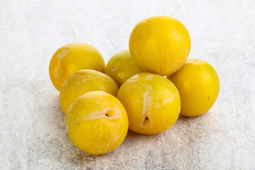 Ripe sweet yellow plum heap over background
