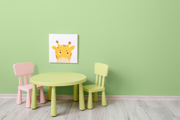 Table, chairs and painting on color wall