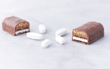 Energy bar and sports supplements on bright stone background. Soft focus. Close up. Copy space.	
