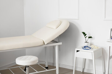 Medical couch and table in modern doctor's office