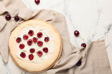 Board with uncooked cherry khachapuri on light background