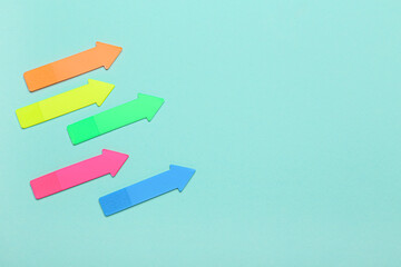 Sticky notes in shape of arrows on blue background
