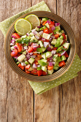 Kachumbari Kenyan Fresh Tomato and Onion Salad close up in the plate. Vertical top view from above