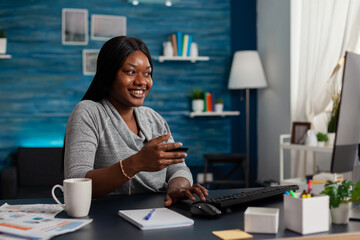Person with credit card preparing to do shopping online on computer and smiling. Woman feeling...