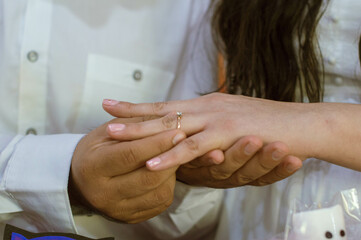 Mano de Novio colocando anillo en mano de prometida para pedir matrimonio a su novia