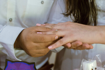 Obraz na płótnie Canvas Mano de Novio colocando anillo en mano de prometida para pedir matrimonio a su novia