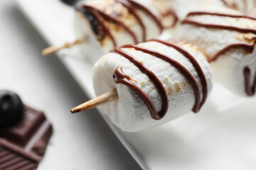 Plate of tasty grilled marshmallows on light background, closeup