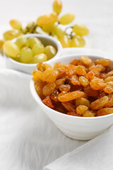 Fototapeta premium Bowl with tasty raisins on table, closeup