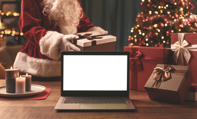 Santa Claus bringing Christmas, gifts and laptop