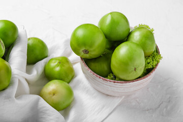 Fototapeta na wymiar Bowl with fresh green tomatoes on white background