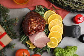 Festive flat lay composition with delicious ham on grey table. Christmas dinner