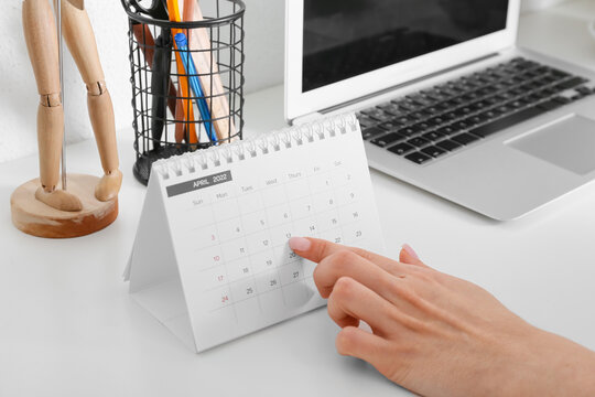 Woman with flip calendar at workplace