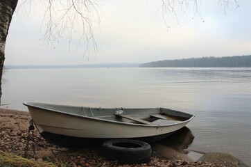 boat on the shore of a calm lake, landscape in neutral colors
