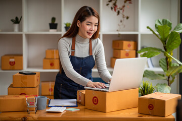 Portrait of Asian young woman SME working with a box at home the workplace.start-up small business...