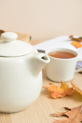 Tea pot and autumn leaves on table, closeup