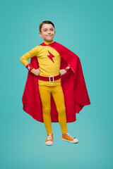 Confident superhero boy in costume in studio