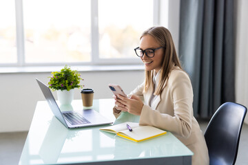 Young businesswoman use phone for text or surfing in internet in modern office.