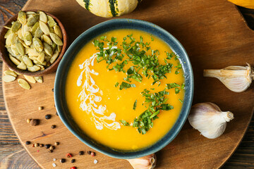 Bowl with delicious pumpkin cream soup and spices on table, closeup