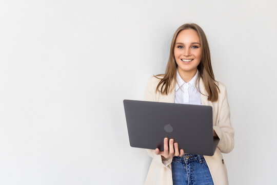 Portrait of a businesswoman holding laptop and looking away isolated over white background