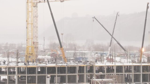 video time-lapse construction of a multi-storey building, in winter, snow, fog