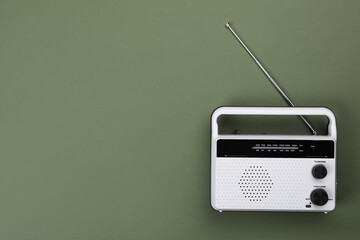 Retro radio receiver on olive background, top view. Space for text