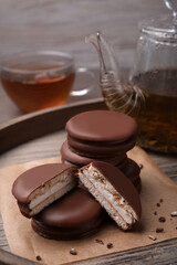Tasty choco pies and tea on wooden tray