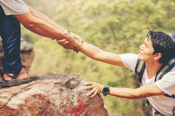 Close up of hand helping each other hike up a mountain. Help and support concept.	 - obrazy, fototapety, plakaty