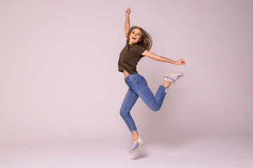 Fototapeta na wymiar Portrait of a cheerful cute woman jumping on a white background