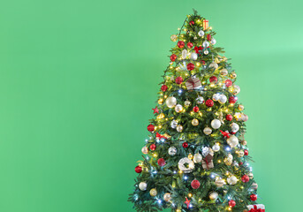 Beautiful decorated Christmas tree on green background