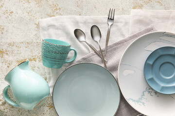 Set of stylish dinnerware on light grunge background - obrazy, fototapety, plakaty