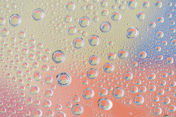 Various colors reflected on small drops of water.