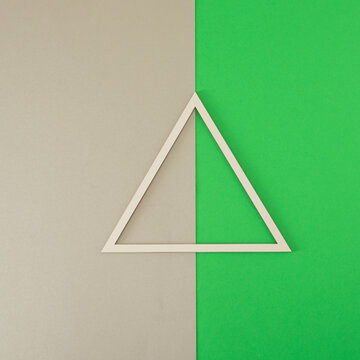 white frame in the shape of a triangle against grey and green background. copy space background. template. retro minimalism