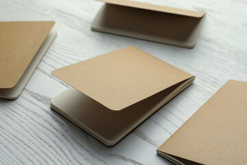 Kraft planners on white wooden table, closeup