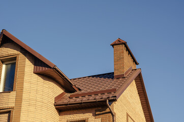 The brown roof with mantel chimney of a beautiful modern stone m