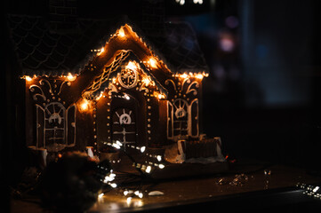 Close-up of gingerbread house with cozy lights. Christmas decorations.