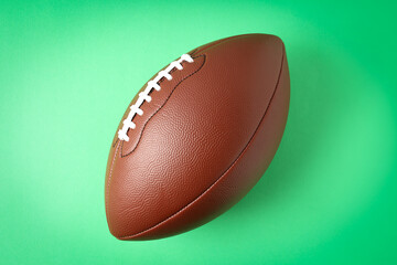 American football ball on mint background, space for text