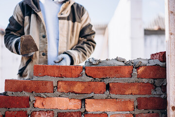 man building brick wall, bricklayer