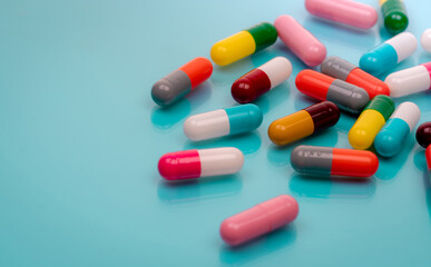 Antibiotic capsule pills on blue background. Prescription drugs. Colorful capsule pills. Antibiotic drug resistance concept. Pharmaceutical industry. Superbug problems. Medicament and pharmacology.