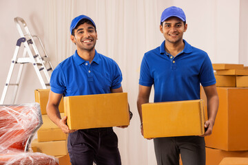 Delivery boys in uniform standing with cardboard boxes
