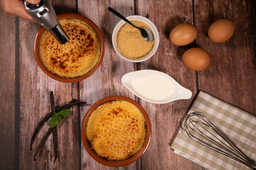 Chef cooks creme brulee with gas burner, dessert in the home kitchen, Cooking at home, professionals for food blog. High quality photo