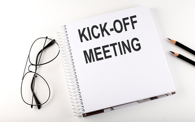 Notepad with text KICK-OFF MEETING . White background. Business concept