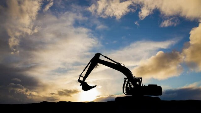 Excavator in construction site on sunset sky background. Timelapse.