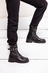 New collection of women's shoes fall-winter 2022. Women's legs in black leather boots.