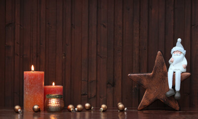 Weihnachtshintergrund: Arrangement mit Kerzen, Stern, Nikolaus und Weihnachtskugeln .