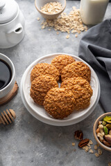 Delicious homemade oat cookies with a cup of coffee, healthy sweet snack, bright background.