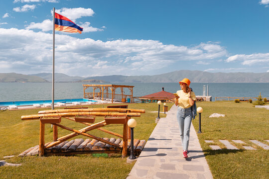 Happy woman walking by the wonderful views of the famous Lake Sevan in Armenia