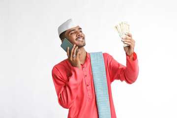 Young indian farmer using smartphone and showing money on white background.